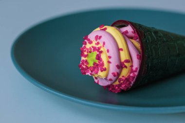 Tabakta dondurma külahı. Limonlu dondurma ve çilekli şerbetle kokulu ahududu parçalarının karışımı..