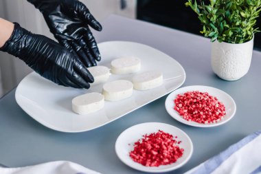 Pasta şefi kuşun sütlü sufle keklerini dondurulmuş ahududu ve çilekle süslüyor.