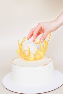 Beyaz pastayı çikolata küresiyle süsleyin.