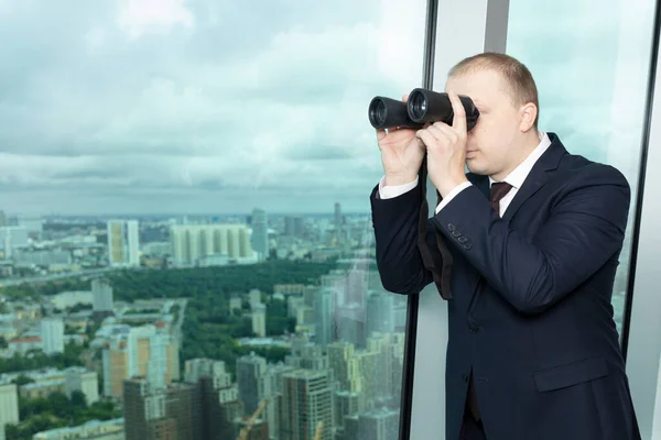 İşletme şefi ofisin penceresinde durup dürbünle dikkatle bakar ve şirketin gelişimine yönelik gelecekteki tasarımları ve olanakları bulur.