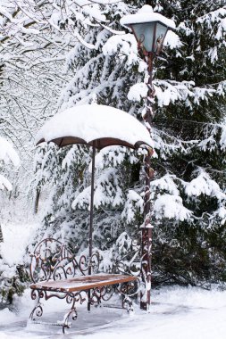 Dekoratif sokak lambaları ve parkta bank. İlk kar. Sahte şemsiye.