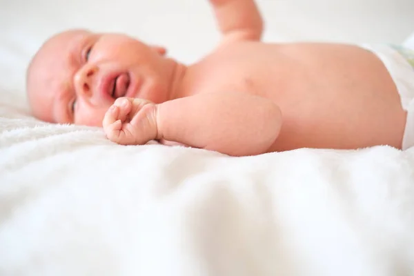 Ein Neugeborenes liegt auf einer weißen Decke. Nahaufnahme Porträt eines Kindes. — Stockfoto