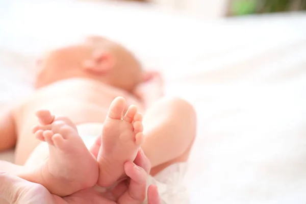 En nyfödd pojke eller flicka ligger på en vit filt. Närbild av ett barn. — Stockfoto
