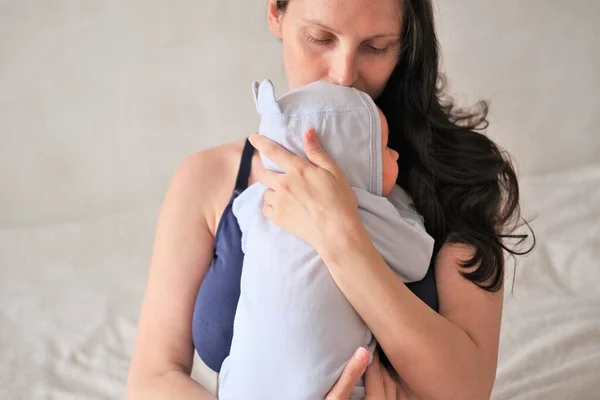 A mãe segura o bebé recém-nascido nos braços. Retrato de um menino ou menina close-up. — Fotografia de Stock