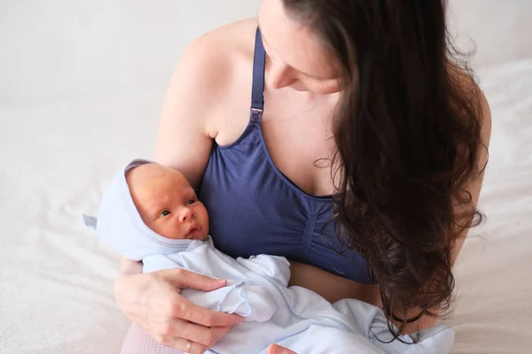 Mam houdt haar pasgeboren baby in haar armen. Portret van een jongen of meisje close-up. Rechtenvrije Stockafbeeldingen