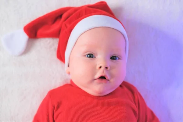 Karácsony, tél, újévi koncepció. Egy jóképű fiú portréja a Mikulás kalapjában. — Stock Fotó
