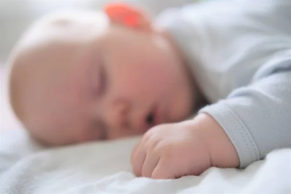 Retrato de un bebé recién nacido durmiendo sobre una manta blanca. — Foto de Stock