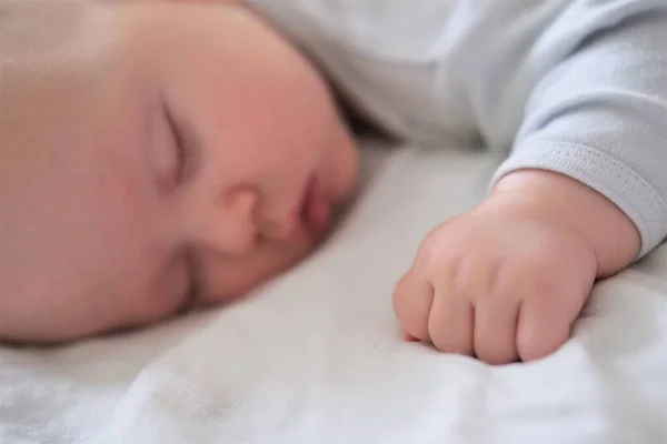 Retrato de un bebé recién nacido durmiendo sobre una manta blanca. — Foto de Stock