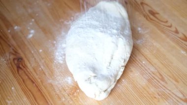 Siyah eldivenli şef ekmek, khinkali, hamur işi ve hamur işi yapmak için hamur yoğurur. Erkek elleri, tahta bir masa arkasına yaslanmış. Yemek pişirme konsepti.