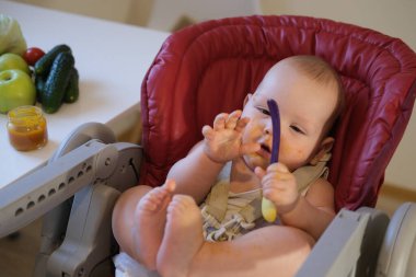 Çocuk sebze ve meyve püresi yiyor. Elma, brokoli, havuç, balkabağı. Bebek maması konsepti