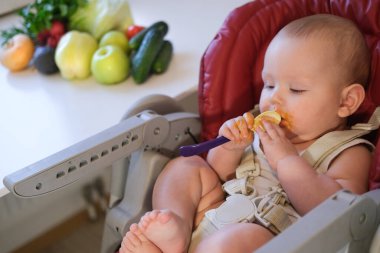 Çocuk sebze ve meyve püresi yiyor. Elma, brokoli, havuç, balkabağı. Bebek maması konsepti