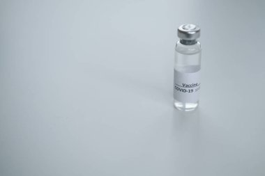 Beyaz arka planda Covid-19 aşısı, yakın plan. Tıp kavramı, salgın hastalıklar. 