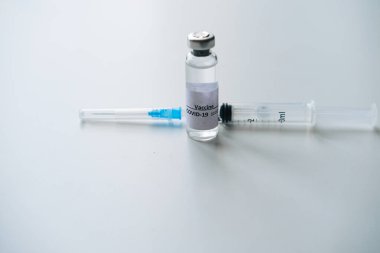 Covid-19 aşısı ve beyaz arka planda enjeksiyon için şırınga, yakın plan. Tıp kavramı, salgın hastalıklar