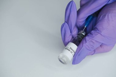 Eldivendeki kadın ellerde koronavirüs aşısı ve şırınga bulunur. Covid-19 konsepti, salgın hastalık, aşı