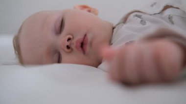 Emziren bebek yataktaki beyaz yatakta uyur..