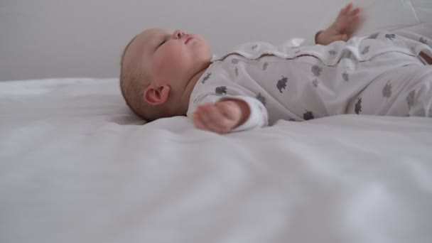 Il bambino che allatta dorme sul letto bianco nel letto. — Video Stock