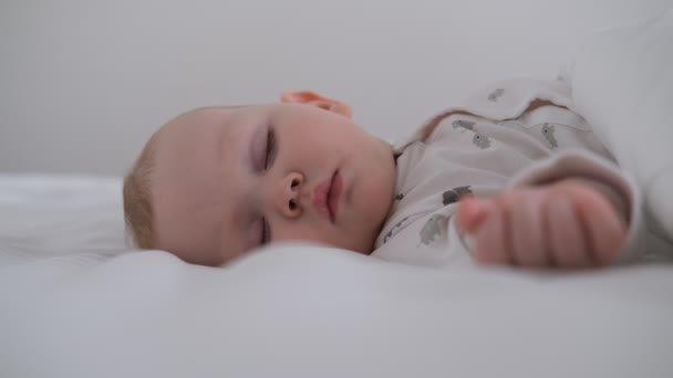 Il bambino che allatta dorme sul letto bianco nel letto. — Video Stock