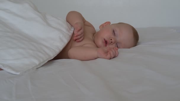 Piccolo bambino addormentato giace su biancheria da letto bianca — Video Stock