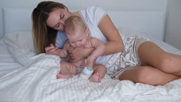 一位年轻的母亲把婴儿抱在怀里摇晃着 婴儿哭了 不想睡觉 — 图库视频影像