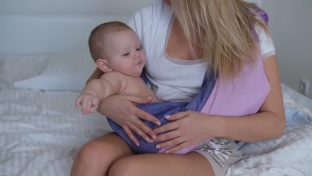 幼い母親が赤ん坊の腕を揺らしている。赤ん坊は泣き、眠りたくない. — ストック動画
