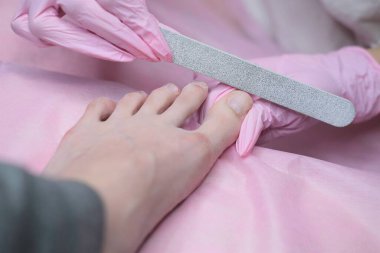 Ortopedi cerrahisi randevusunda olan bir hasta. Elektrikli makinede profesyonel donanım pedikürü. Özel bir elektrikli aletle ayak soymak. 