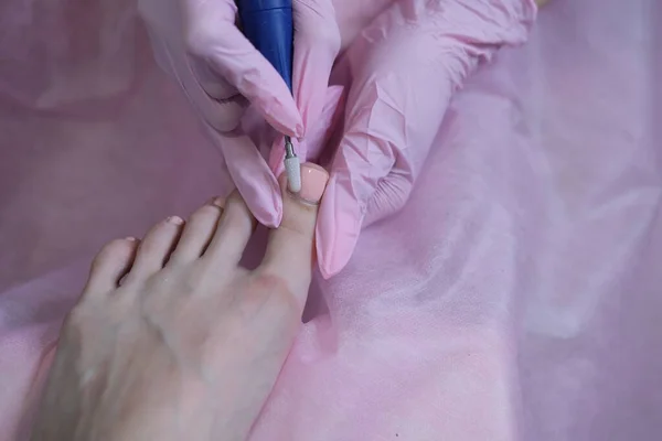 电机上的专业硬脚修补术。用一种特殊的电气设备剥皮脚.在SPA沙龙里的足部护理. — 图库照片