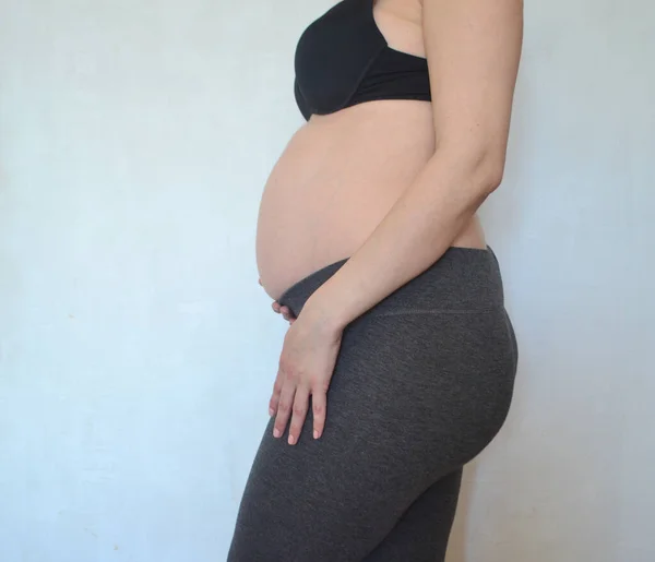 Une Femme Enceinte Tient Contre Mur Blanc Caresse Son Ventre — Photo