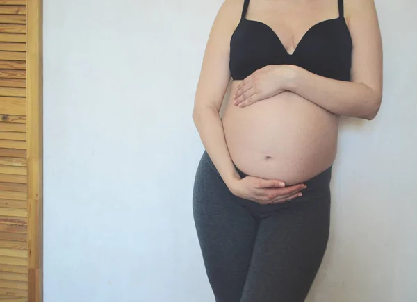 Una Donna Incinta Alza Contro Muro Bianco Accarezza Pancia Concetto — Foto Stock