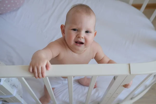 一个站在婴儿床里的小孩的特写。这个蹒跚学步的孩子不想睡在床上. — 图库照片