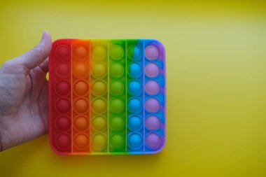 Sarı arka planda çocuklar ve yetişkinler için yeni duyusal anti-stres oyuncağı. 