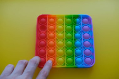 Sarı arka planda çocuklar ve yetişkinler için yeni duyusal anti-stres oyuncağı