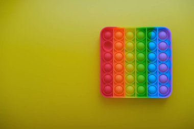 Sarı arka planda çocuklar ve yetişkinler için yeni duyusal anti-stres oyuncağı