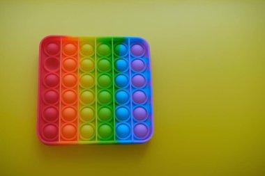 Sarı arka planda çocuklar ve yetişkinler için yeni duyusal anti-stres oyuncağı