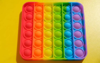 Sarı arka planda çocuklar ve yetişkinler için yeni duyusal anti-stres oyuncağı