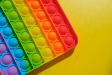 Sarı arka planda çocuklar ve yetişkinler için yeni duyusal anti-stres oyuncağı