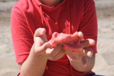  Elinde parlak kırmızı balçık tutan genç bir kız. Eğitim, yaratıcılık, çocukluk kavramı. Seçici odak.