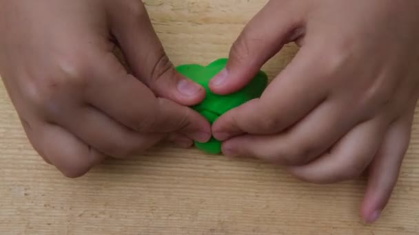 A criança esculpe vários números em uma tábua de madeira da plasticina multicor suave. Close-up — Vídeo de Stock