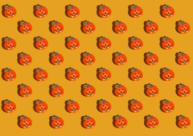 Balkabağı desenli, sarı turuncu arka plan manzaralı dekoratif balkabağı desenli. Sonbahar, Cadılar Bayramı konsepti. Eğilimin gölgesi.