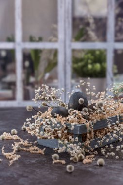 Ahşap bir kutuda koyu renkli yumurtalarla Paskalya kompozisyonu. Söğüt dalı. Paskalya 'nın asgari konsepti. Yazı için yeri olan bir Paskalya kartı..