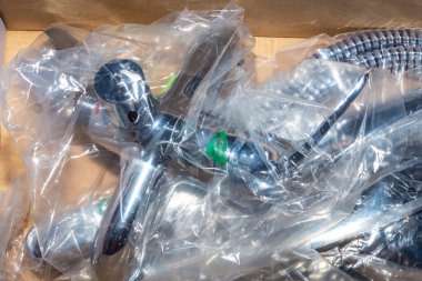 Yeni hijyenik su musluğu ve bir kutuda plastik ambalaj musluğu..