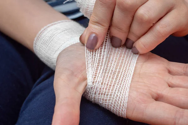 Young Woman Bandages Her Injured Hand White Gauze Bandage Close — Stock Photo, Image