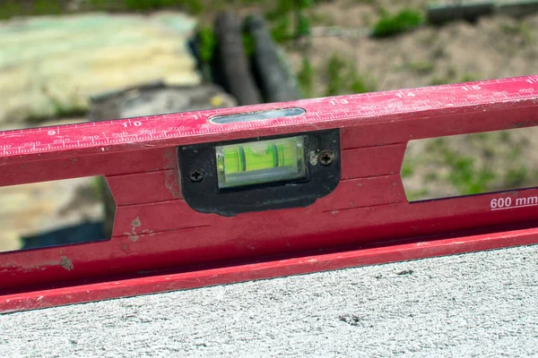 Spirit level mounted on a flat. Using the spirit level, the master measures the correspondence of the surface to a horizontal plane