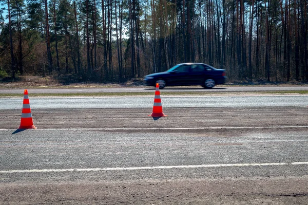 Yol Konileri Hızlı Giden Bir Arabanın Arka Planına Karşı Yolda — Stok fotoğraf