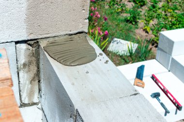 Havalandırmalı beton EPS bloklardan bir duvar örmek için havan topu döşemek. Dış duvarın ACC bloklarından ya da Hebel Bloğundan inşaat.