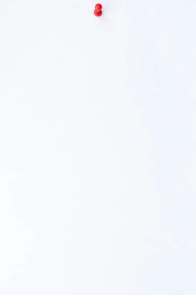 Вертикальный Вид Закройте Белый Лист Бумаги Красной Булавкой Белом Фоне — стоковое фото