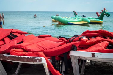 Sahildeki güneş pansiyonlarında bir sürü can yeleği var. Su sürmek için can yelekleri. Suda gezginlerin ve turistlerin güvenliği