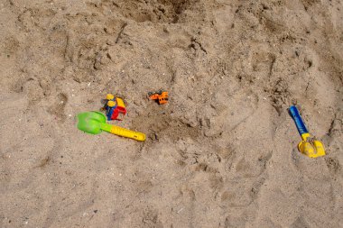 Çocuk oyuncakları - bir kepçe ve oyuncak araba sahilde kumsalda yatıyordu. Üst görünüm