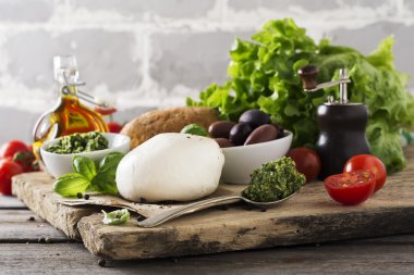 İtalyan mozzarella domates, zeytin ve fesleğen eski ahşap masa üzerinde. Seçici odak