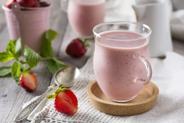 Hafif bir arka plan üzerine bir bardak çilek muz smoothie. Seçici odak. — Stok fotoğraf