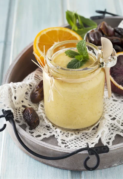 Healthy and fresh orange and date fruit smoothie on blue wooden table. Selective focus. — Stock Photo, Image